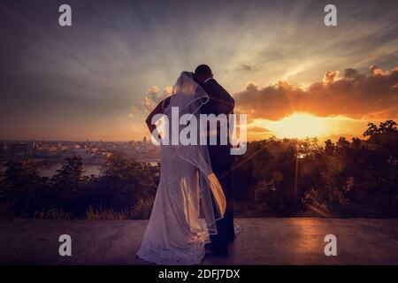 Matrimonio di una coppia soleggiata nello skyline del centro di Cuba al tramonto Foto Stock