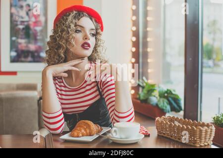 Giovane donna romantica in una caffetteria europea Foto Stock