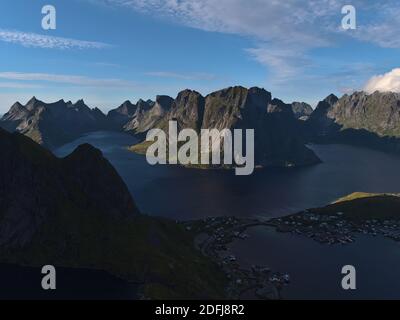 Splendida vista panoramica aerea del villaggio di pescatori Reine, fiordi calmi e la maestosa catena montuosa dell'isola di Moskenesøya, Lofoten nel nord della Norvegia. Foto Stock