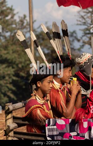 Un giovane Naga ragazzi che si siedono insieme indossando abbigliamento colorato e. Testa gears al villaggio Kisama Heritage a Nagaland India su 3 dicembre 2016 Foto Stock