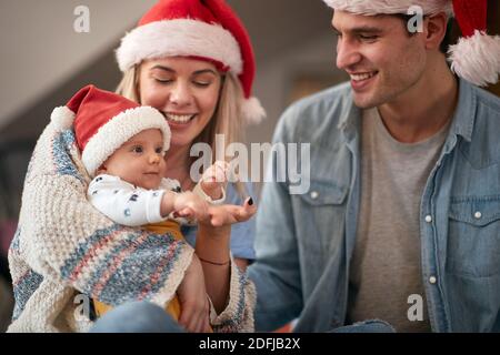 Un bambino e dei genitori in momenti piacevoli alla festa di Capodanno in un'atmosfera allegra a casa. Anno nuovo, concetto di famiglia, insieme, amore Foto Stock