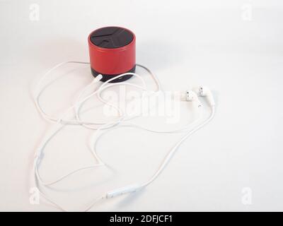 Cuffie collegate a un altoparlante bluetooth. Concetto di musica, eventi e connettività. Foto Stock