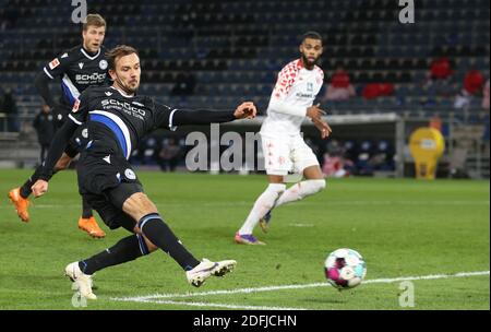 Bielefeld, Germania. 05 dicembre 2020. Calcio: Bundesliga, Arminia Bielefeld - 1° FSV Mainz 05, 10° incontro nella Schüco-Arena. Manuel Prietl (l) di Bielefeld spara il gol dal portiere Zentner (r) da Mainz. Credit: Frito Gentsch/dpa - NOTA IMPORTANTE: In conformità con le norme del DFL Deutsche Fußball Liga e del DFB Deutscher Fußball-Bund, è vietato sfruttare o sfruttare nello stadio e/o nel gioco le fotografie scattate sotto forma di sequenze di immagini e/o serie di foto di tipo video./dpa/Alamy Live News Foto Stock