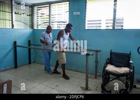 Fisioterapia su una persona disabile paralizzata da malattia di decompressione (DCS) a causa di intensa pesca di aragosta utilizzando metodi di immersione subacquea. Puerto Lempira, Mosquitia, Honduras Foto Stock