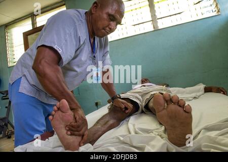 Fisioterapia su una persona disabile paralizzata da malattia di decompressione (DCS) a causa di intensa pesca di aragosta utilizzando metodi di immersione subacquea. Puerto Lempira, Mosquitia, Honduras Foto Stock