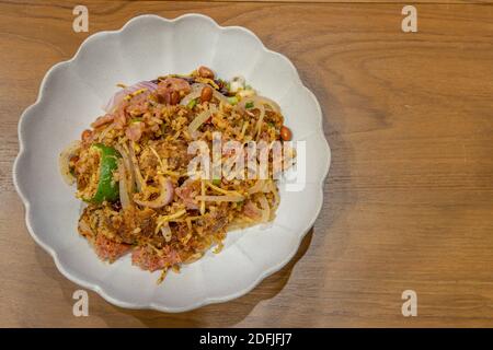 Insalata di maiale fermentata e riso croccante o ricetta di Yam Naem Khao Tod. Cibo tailandese piccante antipasto popolare fatto di riso fritto e pasta di peperoncino mescolato con mar Foto Stock