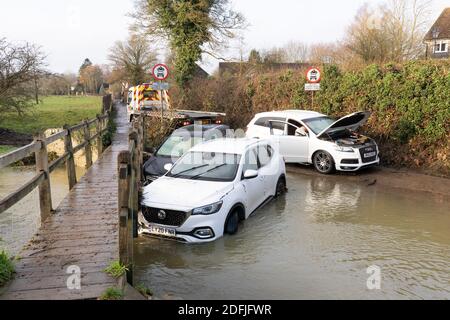 Un camion di recupero si prepara a trainare via i veicoli inondati in trefolo alla ford in molto Hadham. Hertfordshire Regno Unito. Dicembre 2020 Foto Stock