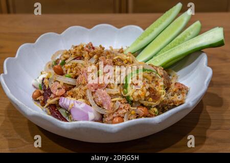 Insalata di maiale fermentata e riso croccante o ricetta di Yam Naem Khao Tod. Cibo tailandese piccante antipasto popolare fatto di riso fritto e pasta di peperoncino mescolato con mar Foto Stock