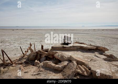 Sedia da ufficio scartata seduta sulla spiaggia del mare in recedimento Salton, Bombay Beach, California Foto Stock