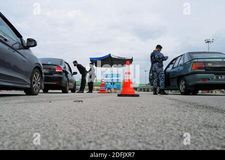 Selangor, Malesia. 5 dicembre 2020. Ufficiali di polizia e un soldato controllano i veicoli in un punto di controllo su un'autostrada in Setia Alam dello stato di Selangor, Malesia, 5 dicembre 2020. Il governo malese ha detto Sabato che estenderà l'ordine di controllo del movimento in diverse aree fino al 20 dicembre per controllare la diffusione di COVID-19. Sabato, il Ministero della Salute della Malesia ha segnalato 1,123 nuovi casi confermati COVID-19, portando il totale nazionale a 71,359. Credit: Zhu Wei/Xinhua/Alamy Live News Foto Stock