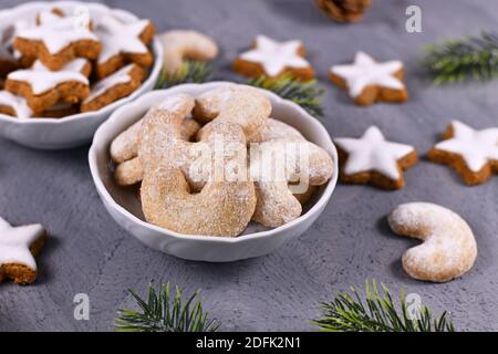 Biscotti natalizi a forma di mezzaluna chiamati "Vanillekipferl", biscotti natalizi tradizionali austriaci o tedeschi con noci e zucchero a velo in ciotola Foto Stock