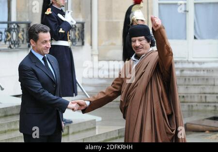 File photo datato 10 dicembre 2007 del leader libico Moammar Gadhafi scuote le mani con il presidente Nicolas Sarkozy prima del loro incontro al Palazzo Elysee a Parigi, Francia. I pubblici ministeri francesi hanno messo l'ex presidente Nicolas Sarkozy sotto indagine formale per 'associazione criminale' venerdì in relazione alle accuse che egli ha accettato il finanziamento della campagna da parte dell'ex forte libico Muammar Gheddafi. I pubblici ministeri stanno indagando sulle accuse secondo cui l'ex leader libico Muammar Gheddafi ha concesso segretamente a Sarkozy 50 milioni di euro per la sua campagna presidenziale inaugurale nel 2007. Le accuse sono state fatte per la prima volta da Foto Stock