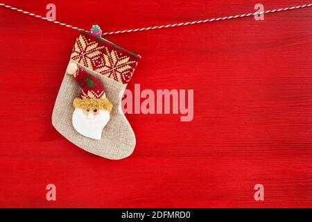 Calza rossa di Natale background.Christmas con Babbo Natale su sfondo rosso di legno. Spazio di copia Foto Stock