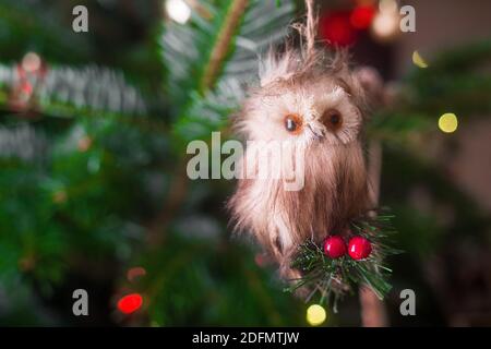 OWL ornamento di Natale. Bellissimo primo piano di un piccolo gufo guardando la macchina fotografica e impiccato su un albero di Natale. Sembra un animale farcito. Foto Stock