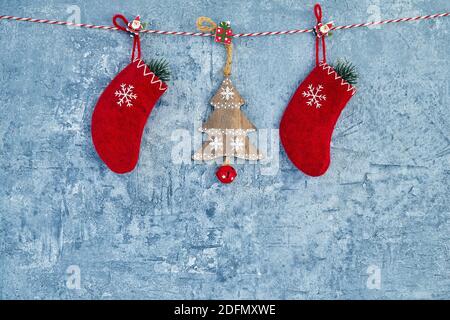 Sfondo di Natale. Decorazione rossa di Natale appesa su corda su sfondo blu. Spazio di copia. Foto Stock