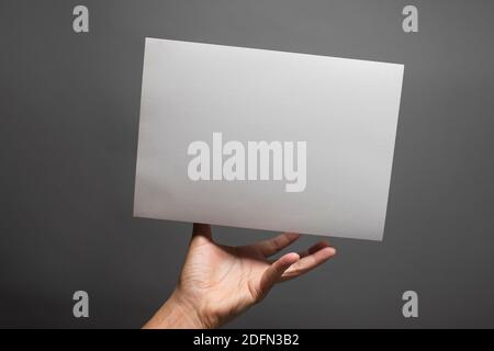 Estrarre la mano per afferrare la carta che galleggia nel aria Foto Stock