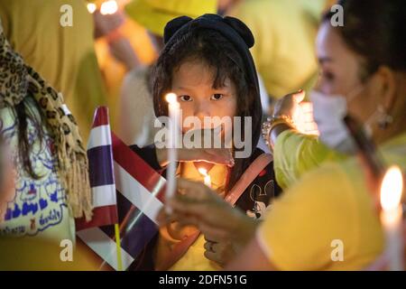 Bangkok, Thailandia. 05 dicembre 2020. Un giovane sostenitore roialista thailandese accende una candela di fronte al Grand Palace di Sanam Luang durante una cerimonia per celebrare il compleanno del defunto re thailandese Bhumibol Adulyadej (Rama 9). Il re tailandese Maha Vajiralongkorn (Rama 10), ha preso parte alla cerimonia insieme ad altri membri della Famiglia reale. Credit: SOPA Images Limited/Alamy Live News Foto Stock