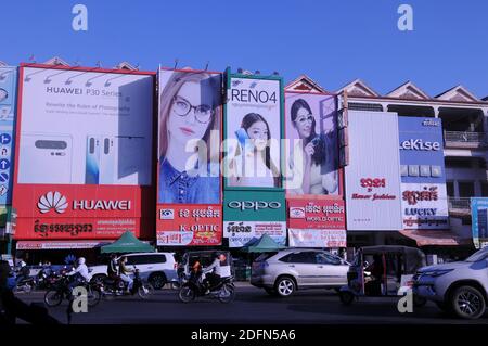 cartelloni pubblicitari giganti per negozi di smartphone e negozi ottici con traffico sottostante. Steung Meanchey, Phnom Penh, Cambogia. © Kraig Lieb Foto Stock