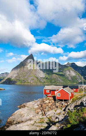 Rorbuer capanne di pesca da Hamnoy, Reinefjord con montagne sullo sfondo, Reine, Lofoten, Norvegia Foto Stock