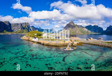 Rorbuer cabine presso il fiordo con Bergen sullo sfondo, villaggio di pescatori Sakrisoy, Sakrisoy, Reine, Lofoten, Norvegia Foto Stock