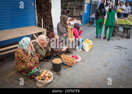 Le Saleswomen sedono sul pavimento, davanti a loro cipolle e cipolle di perla, mercato centrale, Dushanbe, Tagikistan Foto Stock