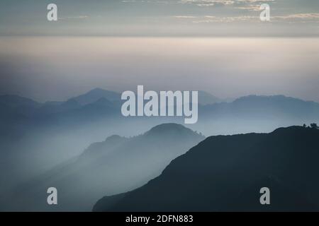 Strati di cime di montagna coperte di nebbia Foto Stock