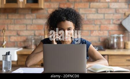 Felice giovane donna d'affari afroamericana che parla con il cliente sul cellulare. Foto Stock