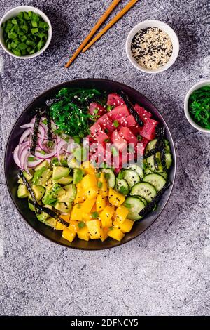 Ciotola hawaiana con alga marina, avocado, mango, cetriolo, vista dall'alto. Foto Stock