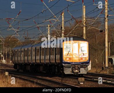 Uno dei "nuovi" treni bimodali del Nord passa vicino a Balshaw Lane Euxton in una prova da Blackpool a Wigan su una mattinata di inverno soleggiato Foto Stock