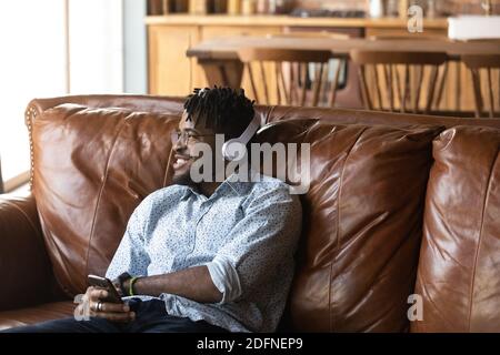 Un giovane sognante che ascolta la musica in cuffia. Foto Stock