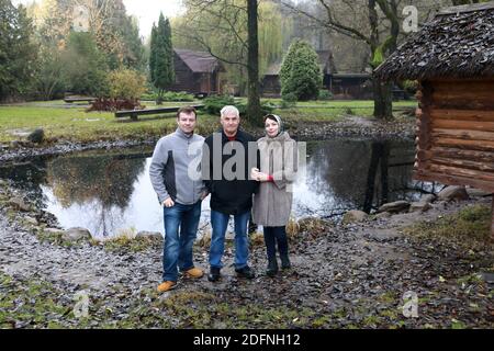 Famiglia in posa sullo sfondo di stagno in autunno Foto Stock