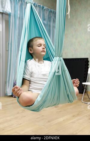 I bambini praticando lo yoga aereo in palestra Foto Stock