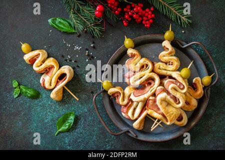 Spuntino di Natale albero di Natale con olive e pancetta e decorazioni natalizie su un tavolo di ardesia. Natale e Capodanno sfondo per il cibo. Foto Stock