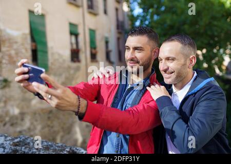 Coppia gay che fa un selfie con il loro smartphone. Foto Stock