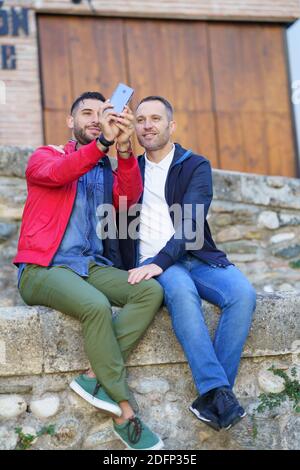 Coppia gay che fa un selfie con il loro smartphone. Foto Stock