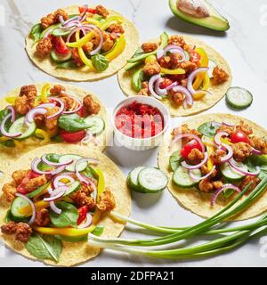 tacos di pollo con avocado, cetriolo, foglie di spinaci freschi, strisce di pepe e cipolla su un tavolo di marmo, cucina messicana, vista orizzontale da ab Foto Stock