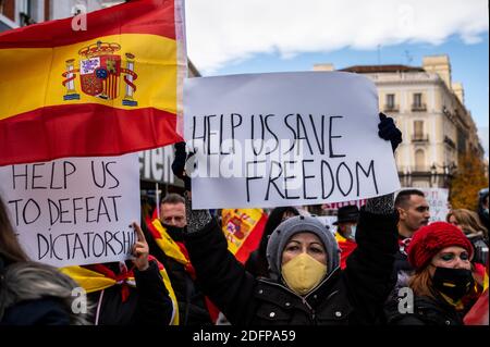 Madrid, Spagna. 06 dicembre 2020. Manifestanti con cartelli che sventolano bandiere spagnole durante una manifestazione in marcia al Congresso dei deputati per protestare contro il governo e chiedere le dimissioni del Presidente Pedro Sanchez coincidendo con l'atto centrale del giorno della celebrazione della Costituzione spagnola che si celebra in seno al Congresso di Dipendenti. Credit: Marcos del Mazo/Alamy Live News Foto Stock