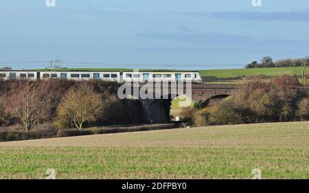 Treno suburbano costituito dalla classe 700 UEM n. 700052 in campagna tra Hitchin e Letchworth, Hertfordshire, Inghilterra, Regno Unito Foto Stock