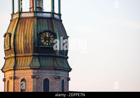 Simbolo di riga, vecchio orologio sulla torre medievale della chiesa di San Pietro tra tetti antichi edifici con architettura europea Foto Stock