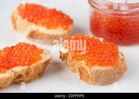 Caviale rosso e burro costosi su pane tostato. Antipasto russo per le vacanze Foto Stock