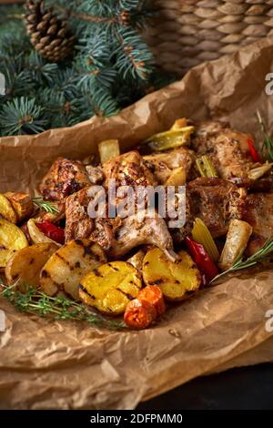 Delizioso coniglio brasato con tavolo vecchio di vegetableson scuro, ricetta di Natale per cena, verticale Foto Stock