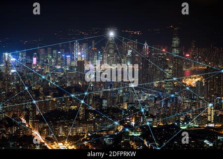 Città intelligente e linee di collegamento. Paesaggio urbano di Hong Kong, Cina, di notte. Tecnologia, connessione di rete, informazioni e concetto di città intelligente. Foto Stock