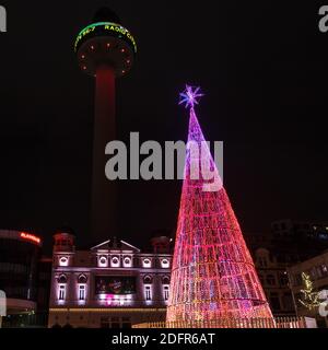 Un grande albero di Natale colorato catturato in Williamson Square a Liverpool di fronte al teatro Playhouse nel dicembre 2020. Foto Stock