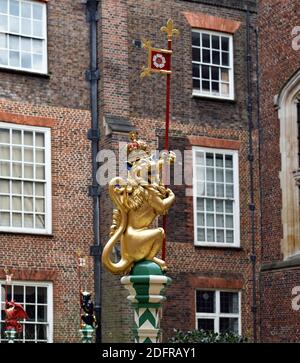 Il giardino Chapel Court all'Hampton Court Palace, Londra. Una bestia dorata scolpita in quercia inglese ad un disegno di Tudor si erge sulla cima di un palo verde e bianco Foto Stock