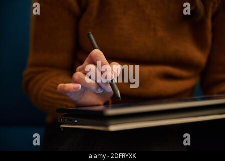 Primo piano di una persona che scrive su un tablet. Primo piano di una persona che lavora su un tablet. Persona che scrive su un convertibile. Foto Stock