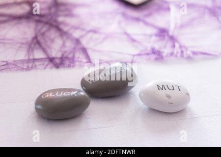 decorazione viola per battesimo e pietre bianche e grigie con parole scritte Foto Stock