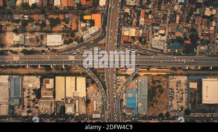 In cima alle strade del traffico a Manila città vista aerea paesaggio urbano. Incredibile paesaggio urbano con auto e autobus sulla strada. Grattacieli del centro, edifici tetti della capitale delle Filippine Foto Stock