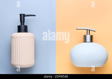 Flaconi dispenser con sapone liquido su sfondo colorato Foto Stock