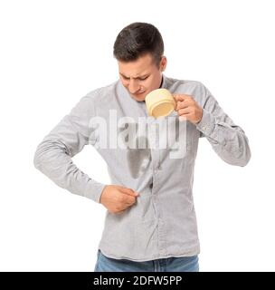 Giovane stressato con macchie di caffè sulla camicia sfondo bianco Foto Stock