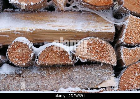 Una pila di legna da ardere con neve e brina in inverno Foto Stock